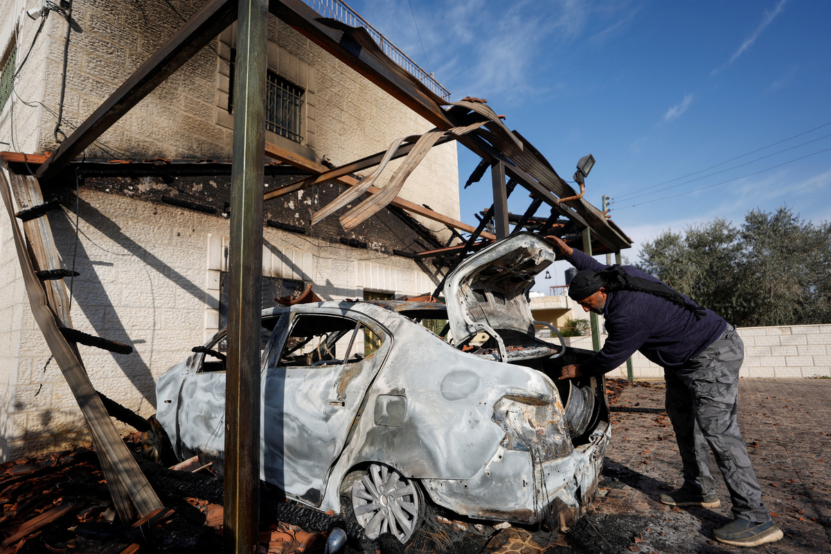 Un hombre palestino revisa un auto dañado